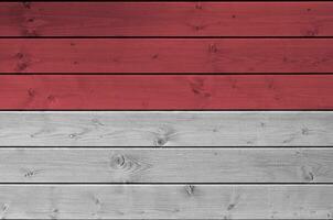 Indonesia flag depicted in bright paint colors on old wooden wall. Textured banner on rough background photo