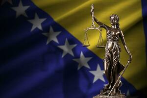 Bosnia and Herzegovina flag with statue of lady justice and judicial scales in dark room. Concept of judgement and punishment photo