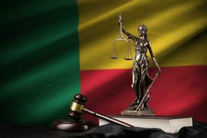 Benin flag with statue of lady justice, constitution and judge hammer on black drapery. Concept of judgement and guilt photo