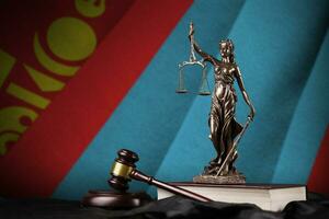 Mongolia flag with statue of lady justice, constitution and judge hammer on black drapery. Concept of judgement and guilt photo