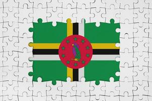 Dominica flag in frame of white puzzle pieces with missing central part photo