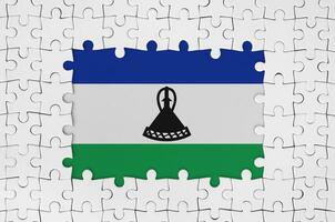 Lesotho flag in frame of white puzzle pieces with missing central part photo