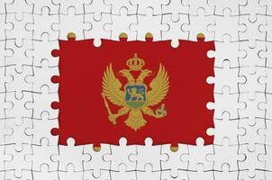 montenegro bandera en marco de blanco rompecabezas piezas con desaparecido central parte foto