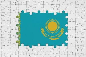 Kazakhstan flag in frame of white puzzle pieces with missing central part photo