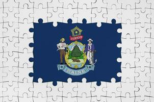 Maine US state flag in frame of white puzzle pieces with missing central part photo