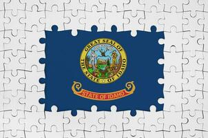 Idaho US state flag in frame of white puzzle pieces with missing central part photo