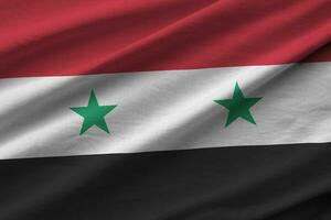 Syria flag with big folds waving close up under the studio light indoors. The official symbols and colors in banner photo