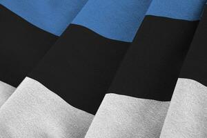 Estonia flag with big folds waving close up under the studio light indoors. The official symbols and colors in banner photo