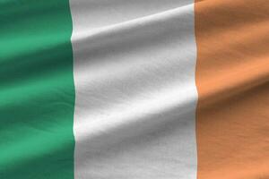 bandera de irlanda con grandes pliegues ondeando de cerca bajo la luz del estudio en el interior. los símbolos y colores oficiales en banner foto