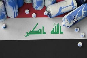 Iraq flag and few used aerosol spray cans for graffiti painting. Street art culture concept photo