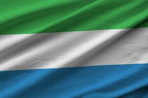 Sierra Leone flag with big folds waving close up under the studio light indoors. The official symbols and colors in banner photo