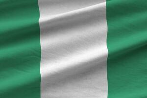 bandera de nigeria con grandes pliegues ondeando de cerca bajo la luz del estudio en el interior. los símbolos y colores oficiales en banner foto