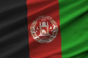 bandera de afganistán con grandes pliegues ondeando de cerca bajo la luz del estudio en el interior. los símbolos y colores oficiales en banner foto