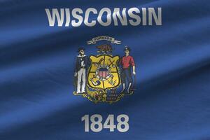 Wisconsin US state flag with big folds waving close up under the studio light indoors. The official symbols and colors in banner photo