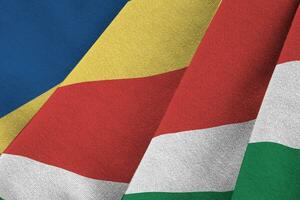 Seychelles flag with big folds waving close up under the studio light indoors. The official symbols and colors in banner photo