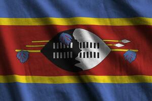 Swaziland flag with big folds waving close up under the studio light indoors. The official symbols and colors in banner photo