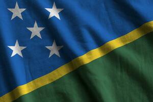 Solomon Islands flag with big folds waving close up under the studio light indoors. The official symbols and colors in banner photo