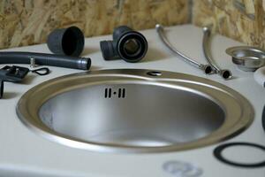 Tools and water tap ready for installation sink on countertop photo