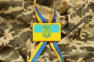 Military camouflage fabric with ukrainian flag on uniform chevron photo