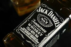 KYIV, UKRAINE - MAY 4, 2022 Jack Daniels original alcohol bottle on wooden table with black fabric photo