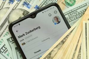 KYIV, UKRAINE - JULY 7, 2023 Threads by Meta application on display of Samsung smartphone and many dollar bills photo