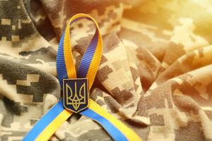 Military camouflage fabric with ukrainian stripes on ribbon photo