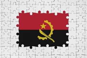 angola bandera en marco de blanco rompecabezas piezas con desaparecido central parte foto