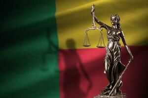 Benin flag with statue of lady justice and judicial scales in dark room. Concept of judgement and punishment photo