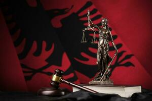 Albania flag with statue of lady justice, constitution and judge hammer on black drapery. Concept of judgement and guilt photo