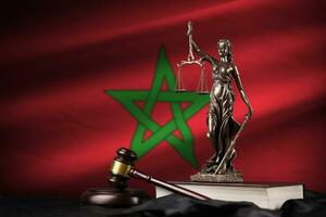 Morocco flag with statue of lady justice, constitution and judge hammer on black drapery. Concept of judgement and guilt photo