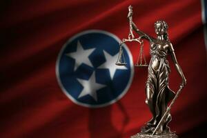 Tennessee US state flag with statue of lady justice and judicial scales in dark room. Concept of judgement and punishment photo