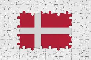 Dinamarca bandera en marco de blanco rompecabezas piezas con desaparecido central parte foto