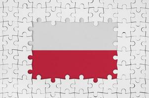 Poland flag in frame of white puzzle pieces with missing central part photo