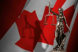 Canada flag with statue of lady justice and judicial scales in dark room. Concept of judgement and punishment photo