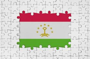 Tajikistan flag in frame of white puzzle pieces with missing central part photo