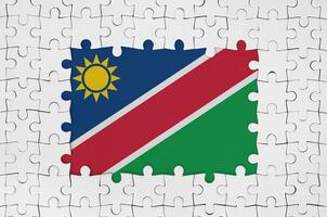 Namibia flag in frame of white puzzle pieces with missing central part photo