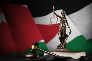 Jordan flag with statue of lady justice, constitution and judge hammer on black drapery. Concept of judgement and guilt photo