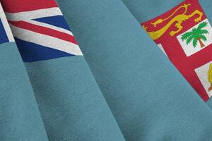 Fiji flag with big folds waving close up under the studio light indoors. The official symbols and colors in banner photo