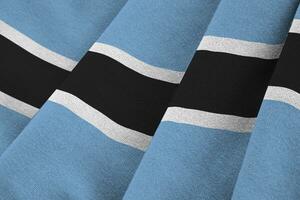 Botswana flag with big folds waving close up under the studio light indoors. The official symbols and colors in banner photo