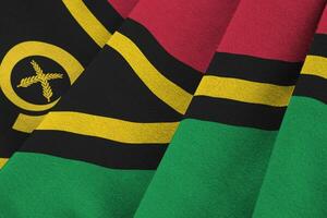 Vanuatu flag with big folds waving close up under the studio light indoors. The official symbols and colors in banner photo