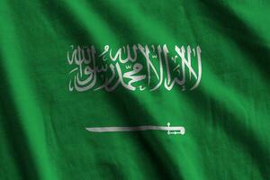 Saudi Arabia flag with big folds waving close up under the studio light indoors. The official symbols and colors in banner photo