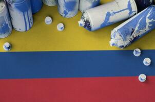 Colombia flag and few used aerosol spray cans for graffiti painting. Street art culture concept photo