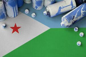 Djibouti flag and few used aerosol spray cans for graffiti painting. Street art culture concept photo