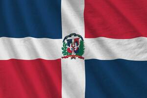 Dominican Republic flag with big folds waving close up under the studio light indoors. The official symbols and colors in banner photo