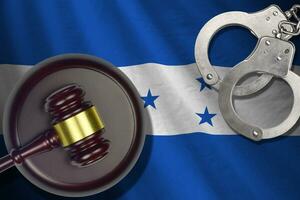 Honduras flag with judge mallet and handcuffs in dark room. Concept of criminal and punishment, background for judgement topics photo