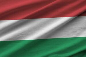 Hungary flag with big folds waving close up under the studio light indoors. The official symbols and colors in banner photo