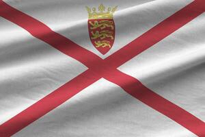 Jersey flag with big folds waving close up under the studio light indoors. The official symbols and colors in banner photo