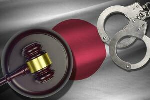 Japan flag with judge mallet and handcuffs in dark room. Concept of criminal and punishment, background for judgement topics photo