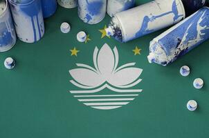 Macau flag and few used aerosol spray cans for graffiti painting. Street art culture concept photo