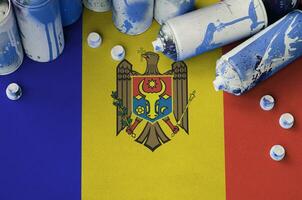 Moldova flag and few used aerosol spray cans for graffiti painting. Street art culture concept photo